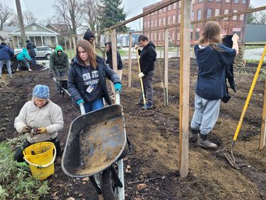 Teenagers and Garden Coaches planting seeds for Farmers Market at their Urban Garden