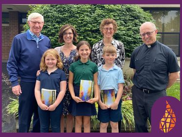 Bob Crowley, Foundation Board Chair, at Saint Joseph School with Carrie Pearson, Principal, Betsy Williams, Advancement Director, and Fr. Tomasone, Pastor, and Saint Joseph School students Julia, Adeline, and Thomas. holding their Choose Christ missals.