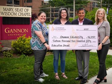 Lisa Louis (Executive Director, right) and Mike Bova (Foundation Board Vice Chair) present grant check to Gannon University Assistant Director of Campus Ministry, Emily Muntean (left) and Stacia Brown (Campus Minister).