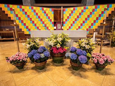 Colored pages bearing names of parishioners adorn the sanctuary at Saint Jude Church while we are unable to gather for Mass.